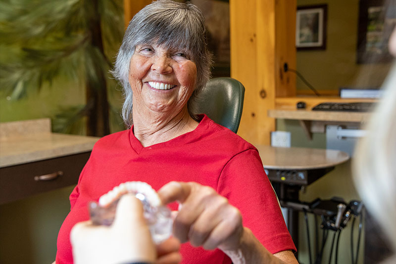 Patient looking at implant model within the dental practice