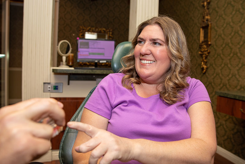 Patient being shown dental implant model within the dental practice